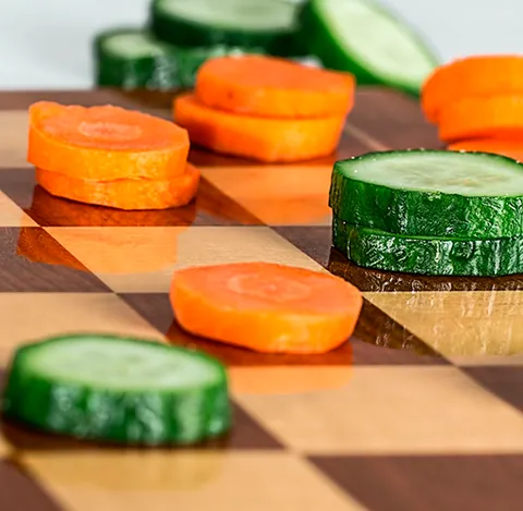 Rodajas de zanahoria y pepino sobre una tabla de madera